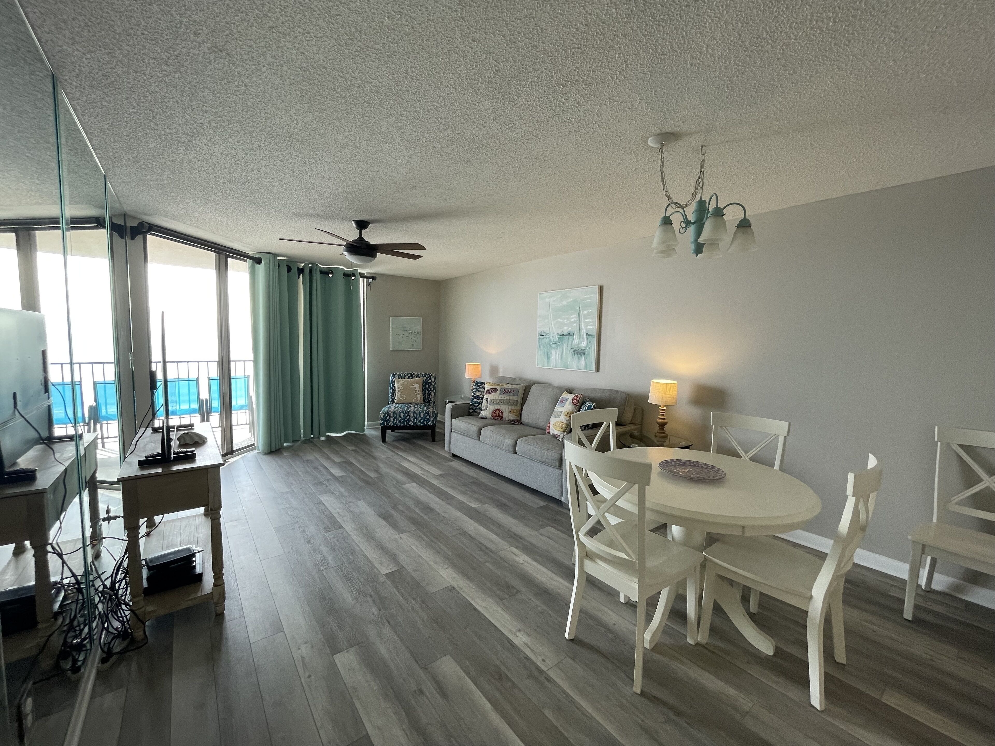 Un salon comprenant un canapé, une table à manger, des chaises et un ventilateur de plafond.
