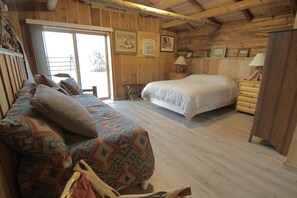 A log cabin bedroom with a bed, a bench, and a dresser. - Large, Private & Charming retreat is ultimate upscale stay near Cody, Y.S. Park (Ralston)