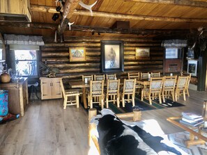A rustic log cabin interior with a dining area, wooden furniture, and framed artwork on the walls. - Large, Private & Charming retreat is ultimate upscale stay near Cody, Y.S. Park (Ralston)