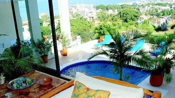 Un balcón con vista a una piscina y al paisaje urbano.