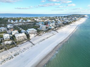 An aerial view of a coastal residential area with houses along the beach, a clear sky, and the ocean in the background. - Stunning Gulf Views/ 4/4 Dog Friendly/Dedicated Boardwalk - SPECIALS! (Port St Joe)