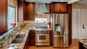 A kitchen with wooden cabinets, a stainless steel refrigerator, and a granite countertop. - 3 Bedrooms - Gourmet Kitchen - Open Floorplan - Near Red Rocks & Near Downtown (Lakewood)