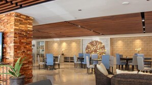 Un lobby moderno con un muro de acento de ladrillo, techo de listones de madera y una gran pieza decorativa de pared.