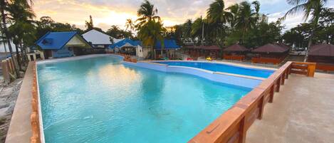 Una piscina al aire libre, camas de piscina con cargo