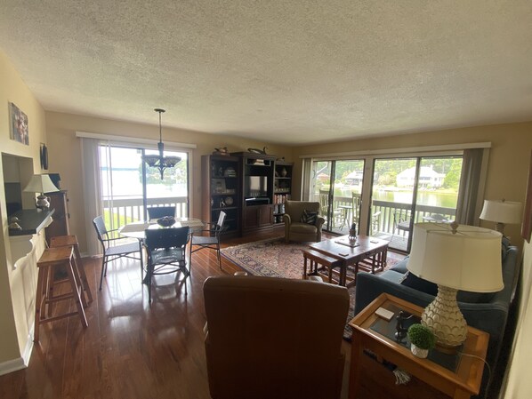 A spacious living room with a large window, a dining area, and a cozy seating area.