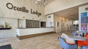 A reception area with a reception desk, chairs, and a wall with the name 'Ocotillo Lodge'.