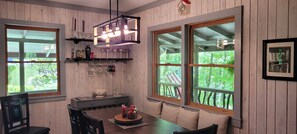 Enjoy meals in this dining area with a table set for four and a shelf above, featuring a clock and framed picture.