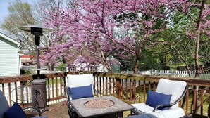 Une terrasse dotée de mobilier d’extérieur, d’un foyer et d’une clôture en bois.