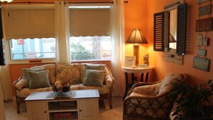 A cozy living room with a sofa, armchairs, a coffee table, and a lamp.