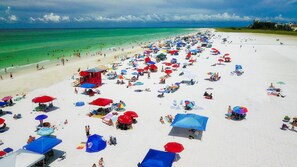 Une plage bondée, avec de nombreux parasols et beaucoup de vacanciers.