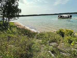 A lakeside view with a dock and a covered structure.