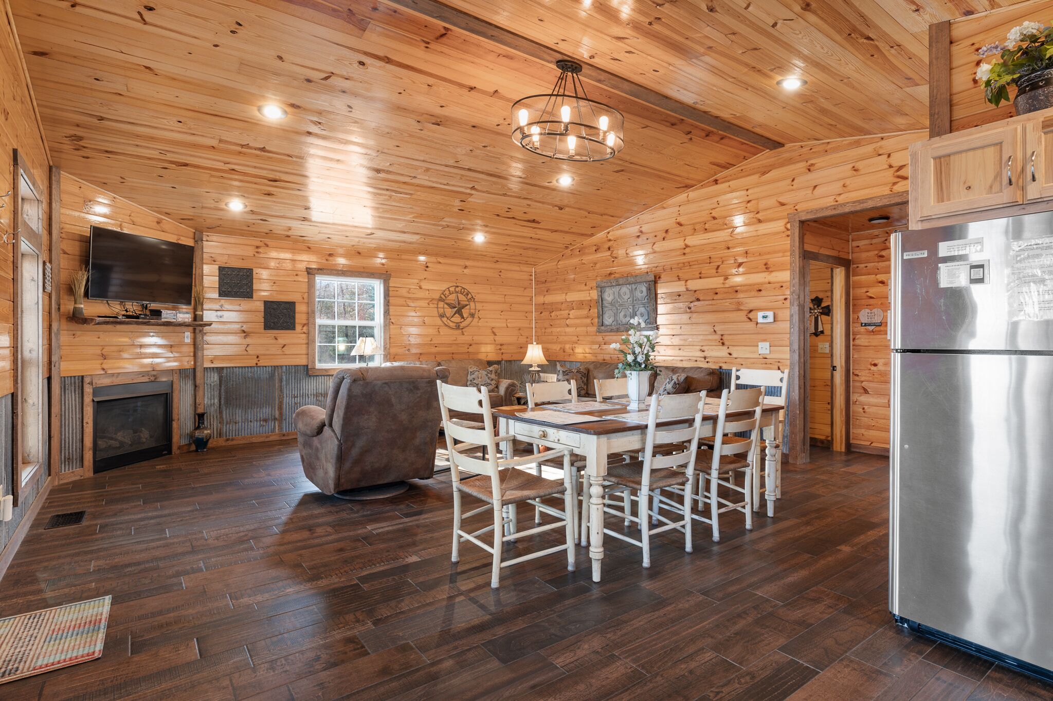L’intérieur d’un chalet en bois comprend un coin repas, une cuisine et une cheminée.