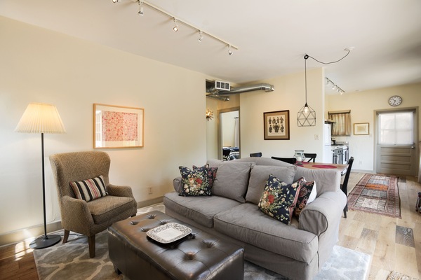 Living room view from fireplace wall, looking toward kitchen and West bedroom.