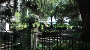 A garden with a fountain, stone benches, and a brick wall. - Resort access & golf cart included. On tidal creek. Easy walk to beach. Reviews+ (Fripp Island)