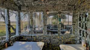 A room with walls and ceiling covered in dollar bills, large windows, and a ceiling fan. - Resort access & golf cart included. On tidal creek. Easy walk to beach. Reviews+ (Fripp Island)
