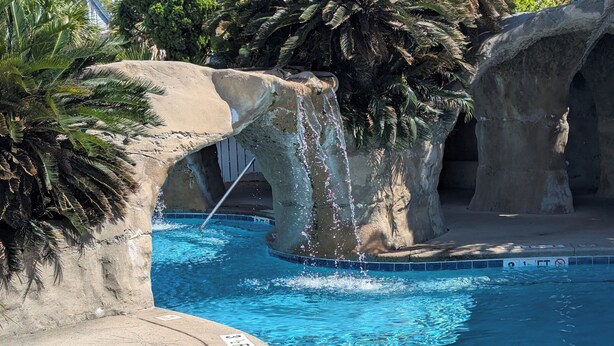 A pool with clear blue water, surrounded by palm trees and rocky formations. - Resort access & golf cart included. On tidal creek. Easy walk to beach. Reviews+ (Fripp Island)