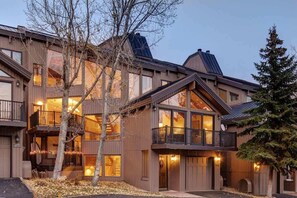 Un edificio de varios pisos con balcones, ventanas amplias y fachada de madera.