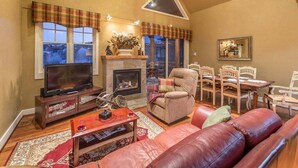 Una sala de estar acogedora con chimenea, televisor y sofá.