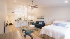 A spacious living area with a large bed, a sofa, a dining table, and a kitchen area. - Beach Condo in Sawgrass Country Club - Steps From the Sand! Recently Renovated. (Ponte Vedra Beach)