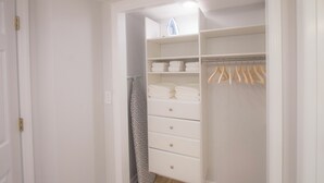 A white walk-in closet with shelves, drawers, and hanging space. - Beach Condo in Sawgrass Country Club - Steps From the Sand! Recently Renovated. (Ponte Vedra Beach)