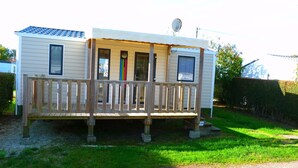 A mobile home with a wooden deck, a satellite dish, and a number '131' on the side. - Camping La Maurie (Saint-Georges-d'Oleron)