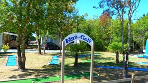 A mini-golf course with a sign reading "Mini-Golf" surrounded by trees and a small building. - Camping La Maurie (Saint-Georges-d'Oleron)