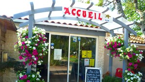 A storefront with a sign reading "ACCUEL" and a chalkboard sign advertising a "Mini-Club" with specific opening hours. - Camping La Maurie (Saint-Georges-d'Oleron)