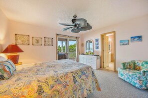 A bedroom with a bed, a ceiling fan, a dresser, a chair, and a door leading to a balcony. - Soundfront Home w/ Hot Tub, Windsports Access, Community Tennis and Pickleball (Rodanthe)