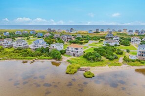 Une zone résidentielle côtière comprenant des maisons, une plage et une étendue d’eau.