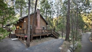 A log cabin with a wooden deck and stairs leading to the entrance.