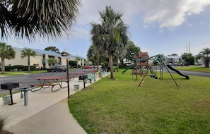 Enjoy a family-friendly outdoor space with a playground, picnic area, and walkway surrounded by lush greenery.