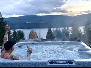 Un jacuzzi con vista a un lago y montañas.