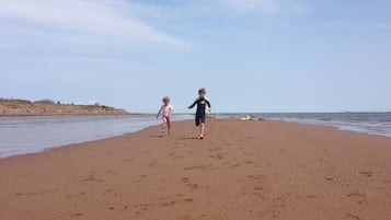 Na praia, espreguiçadeiras, toalhas de praia 