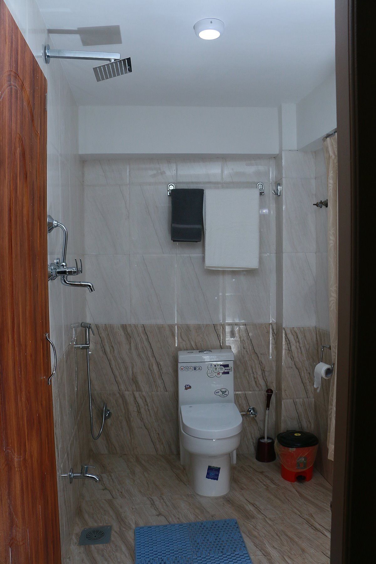 A modern bathroom with a shower, toilet, and sink.