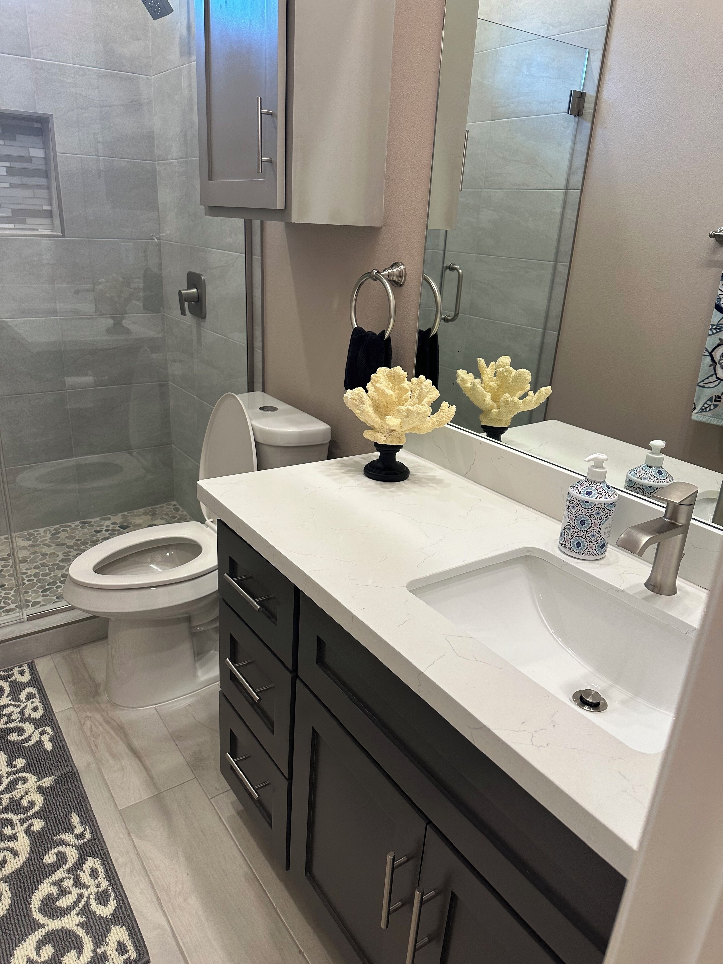 Un baño moderno con inodoro, lavamanos y zona de ducha.