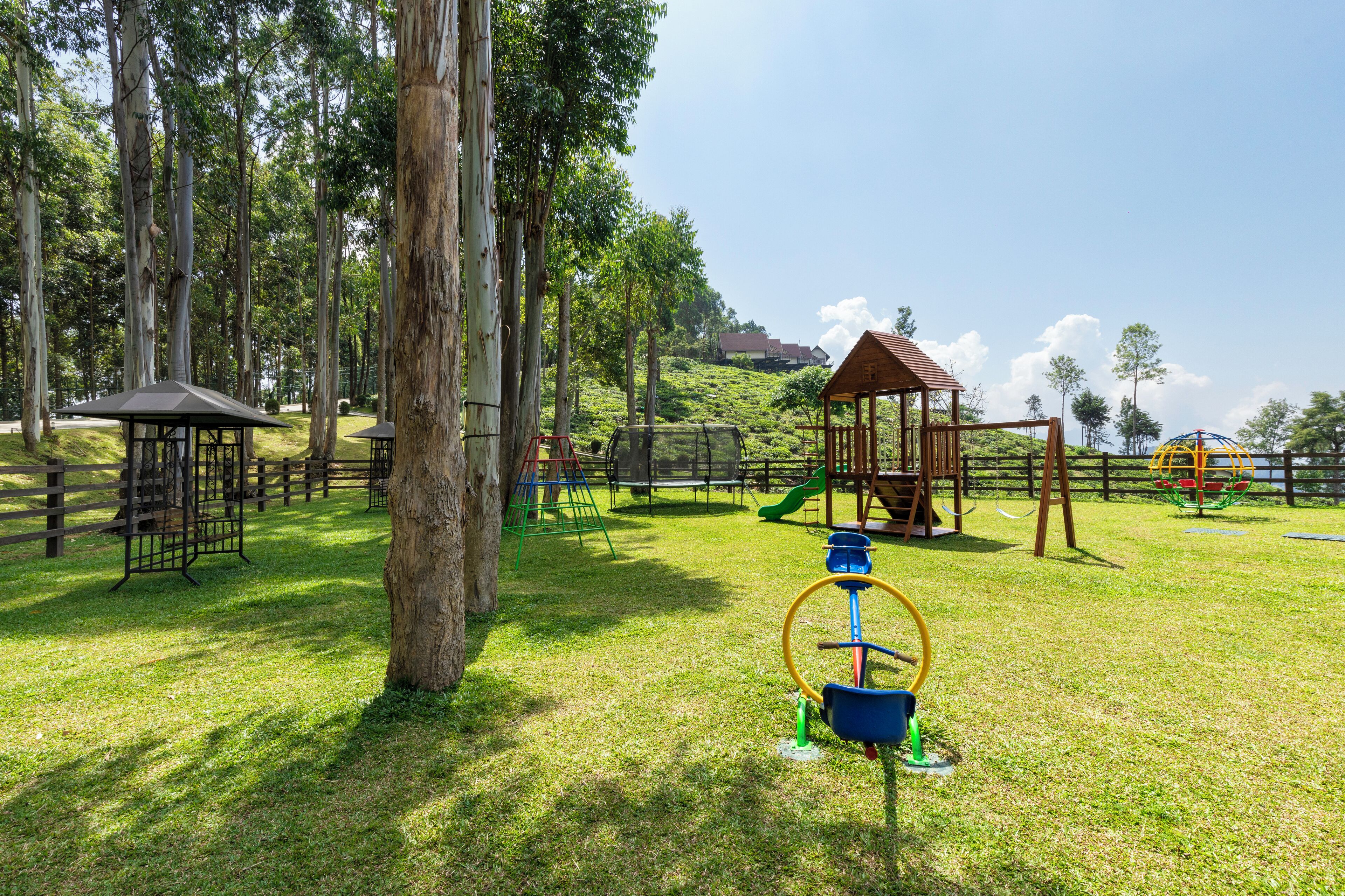 Un parque infantil con diversas estructuras de juego, como columpios, escaleras de cuerda y un tobogán.