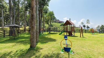 Un parque infantil con diversas estructuras de juego, como columpios, escaleras de cuerda y un tobogán.