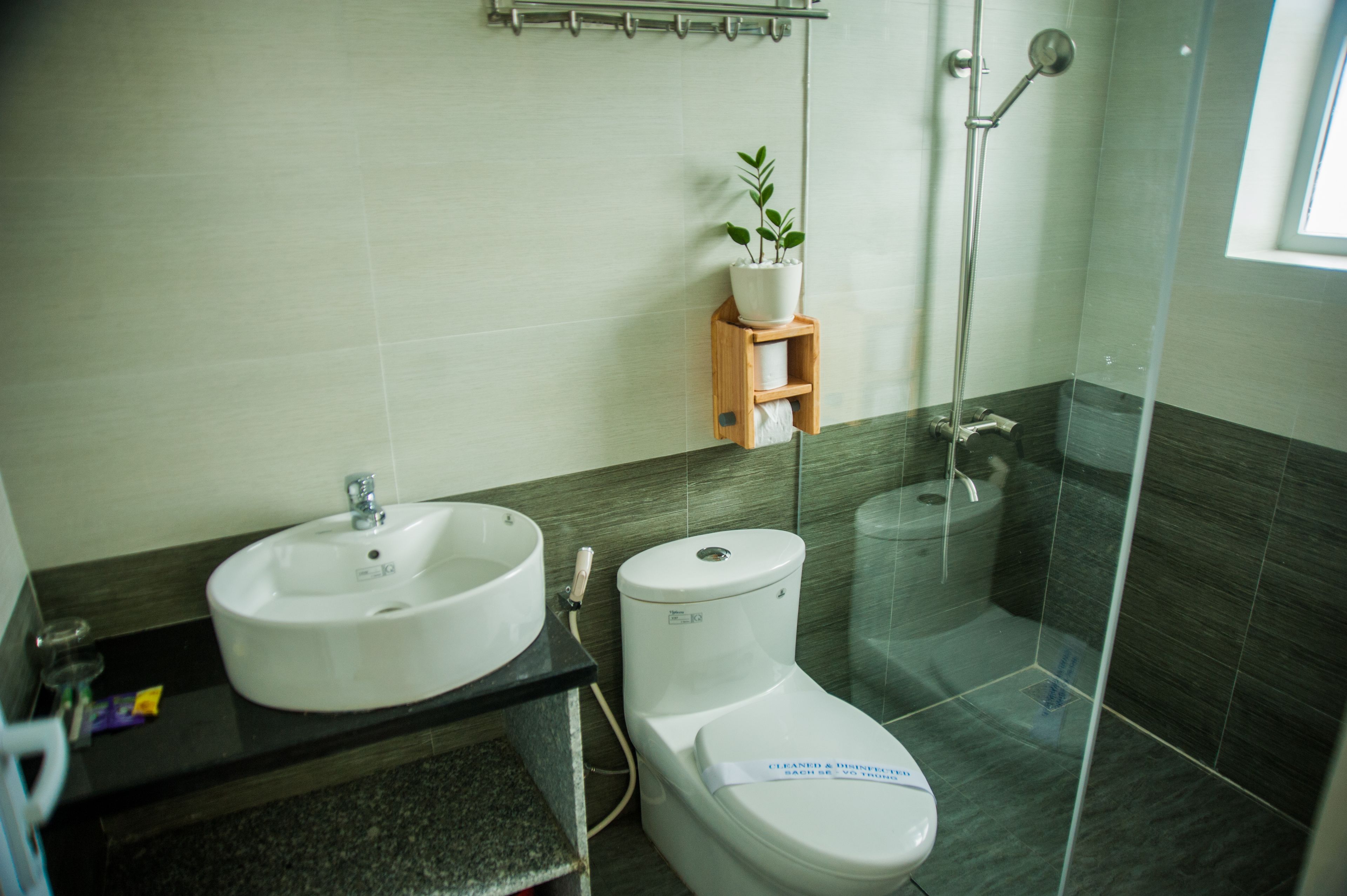Een moderne badkamer met een wastafel, toilet en douche.