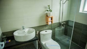 A modern bathroom with a sink, toilet, and shower.