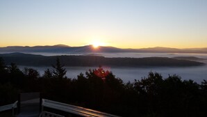Amanecer sobre un paisaje montañoso con un banco al frente.