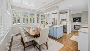 A spacious kitchen with a central island, white cabinetry, and a large dining area with a wooden table and chairs. - Murrells Inlet, SC , Wachesaw Plantation, SC , 2 bed Condo (Murrells Inlet)