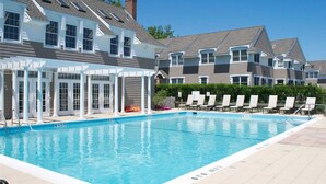 A swimming pool with lounge chairs and a covered patio area. - Hamptons Waterfront With Private Beach & Pool (Hampton Bays)