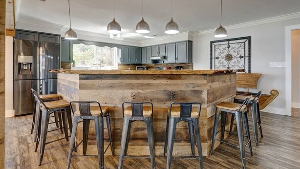 A modern kitchen with a central island, bar stools, and pendant lighting. - Lake Chillin’ at its finest! (Shelby County)