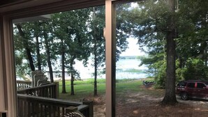 A room with a large window overlooking a lake, a deck, and a parked car. - Lake Chillin’ at its finest! (Shelby County)