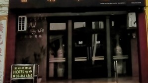 Un hotel con un cartel grande que dice "HOTEL Fully Well", varios pisos y una bandera estadounidense en la parte superior.