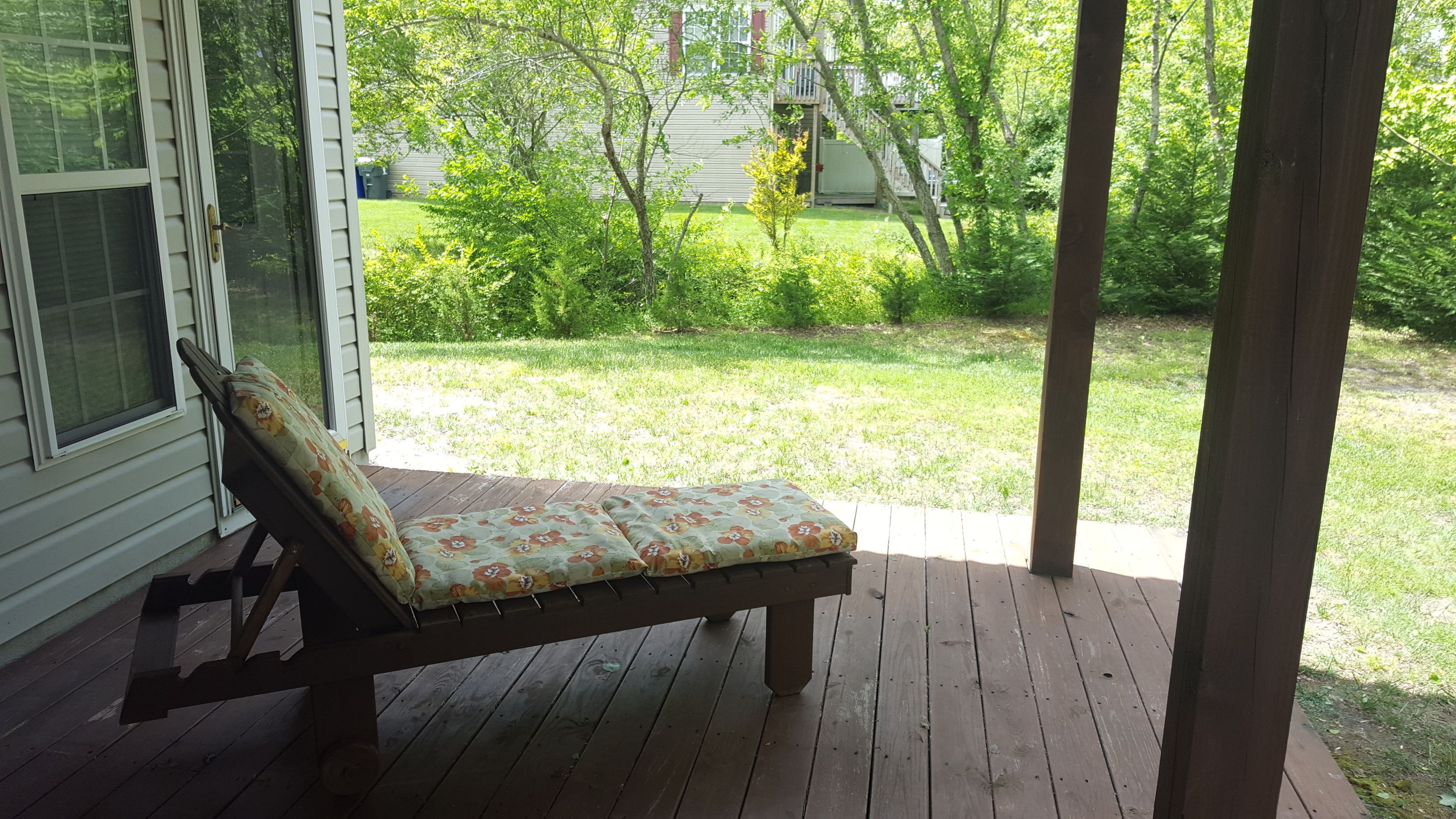 A wooden deck with a cushioned bench.
