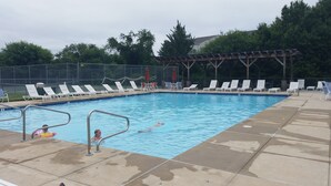Une piscine avec des chaises longues et un espace abrité.
