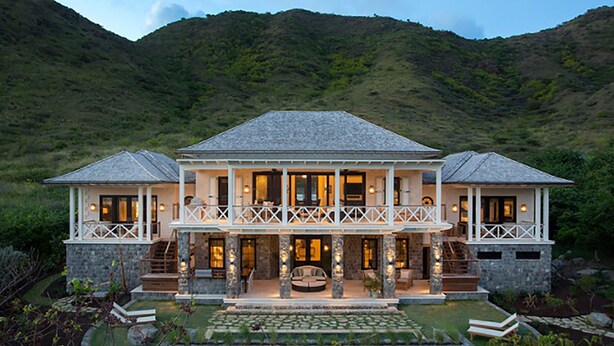 A two-story house with a stone facade, a balcony, and a pool. - Beautiful 4 bedroom Caribbean Villa (Basseterre)