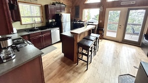 Una cocina amplia con armarios de madera, un refrigerador de acero inoxidable y una zona de bar.
