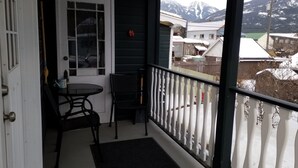 En balkon med udsigt over sneklædte huse og bjerge.